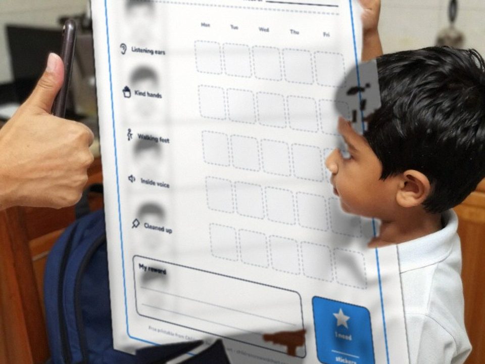 Kindergartener showing his behavior chart with the first star of the week