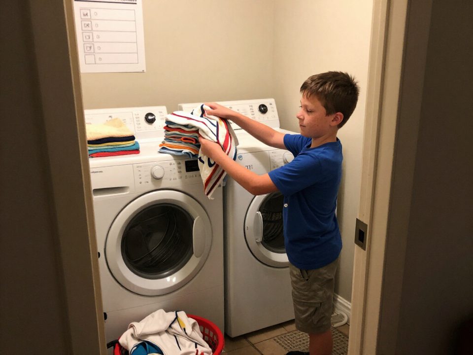 Seven year old folding towels in the laundry room